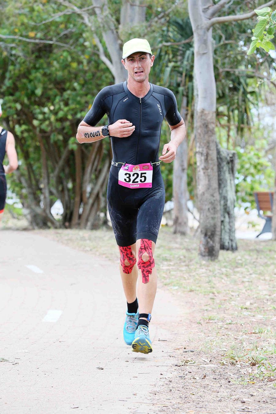 Giuseppe Gambarini running with race number 325 during the run leg of the Hervey Bay 100 triathlon