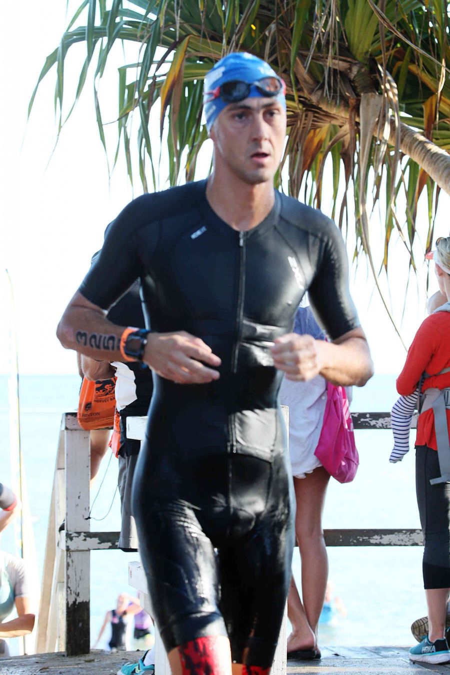 Giuseppe Gambarini coming out of the water in a wetsuit during the swim leg of the Hervey Bay 100 triathlon in Australia